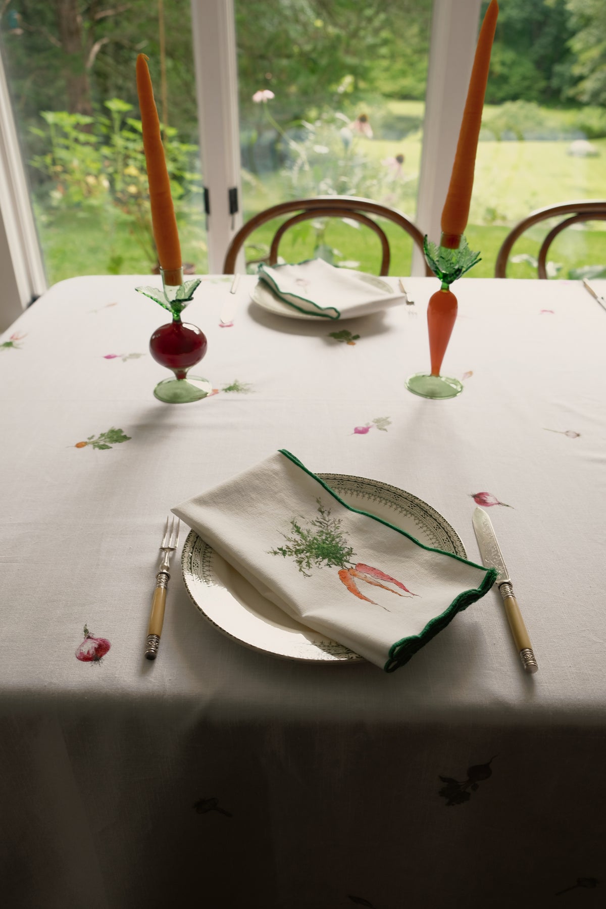 Root Vegetable Tablecloth by a garden window, with an Orange Carrots napkin on a place setting