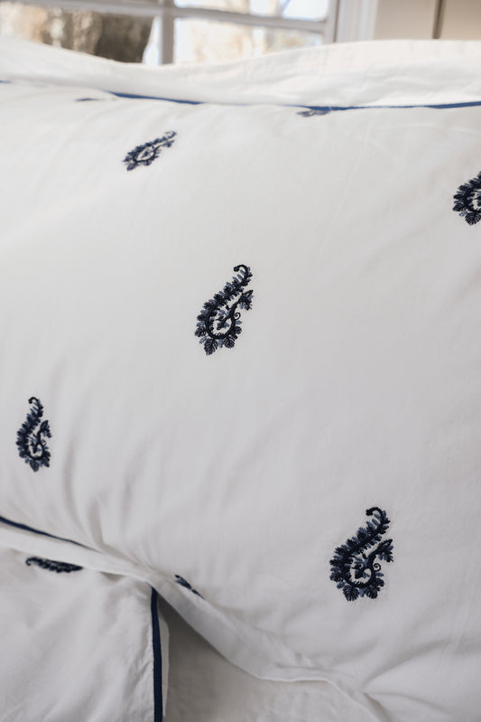 Close-up of the Blue Paisley Embroidered duvet showing the raised navy paisley embroidery and piping