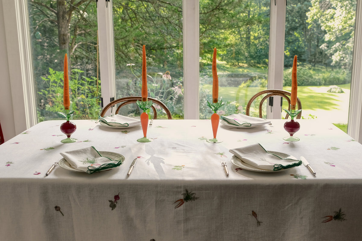 Root Vegetable Tablecloth on a dining table by garden windows, set for four with candlesticks