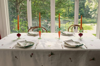 Root Vegetable Tablecloth on a dining table by garden windows, set for four with candlesticks