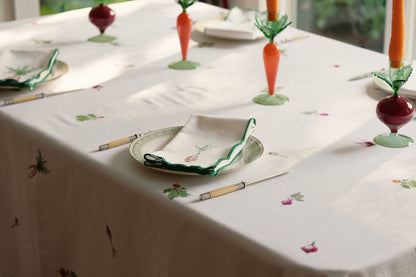 Root Vegetable Tablecloth on a sunlit dining table set with carrot and beet candlesticks and folded napkins