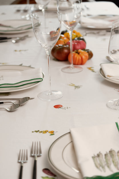 Place settings with wine glasses and heirloom tomatoes on the Summer Vegetable Tablecloth