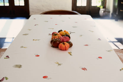 Summer Vegetable Tablecloth on a rectangular table with a centerpiece of heirloom tomatoes and scattered vegetable motifs