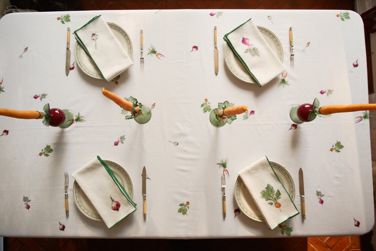 Overhead view of the Root Vegetable Tablecloth set for four, with carrot and beet candlesticks