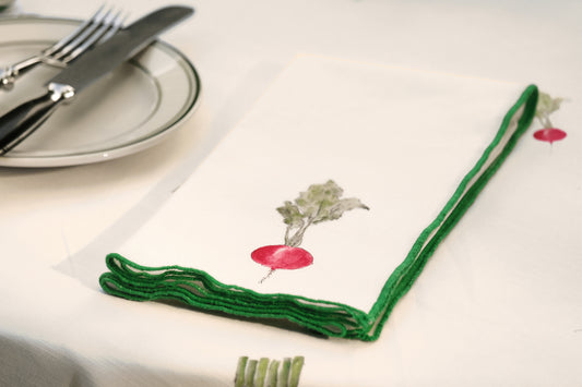 Close-up of the radish print napkin from the Spring Vegetable Napkins set, with its green overlock hem