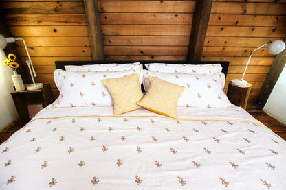 Fields of Gold bedding styled in a warm wood cabin bedroom with sunflowers