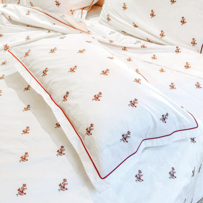 Crimson Meadows percale — red floral motifs and red piping on white cotton