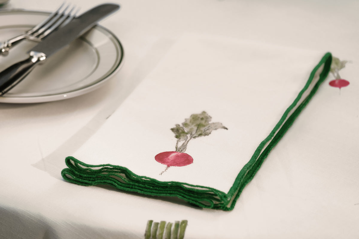 Close-up of the radish print napkin from the Spring Vegetable Napkins set, with its green overlock hem